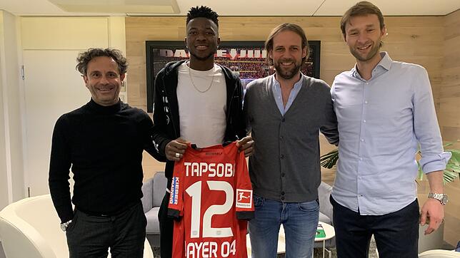 Transfer perfekt: In der Geschäftsstelle von Bayer Leverkusen freuen sich (von links) Spielervermittler Rainer Störk, Edmond Tapsoba, ...