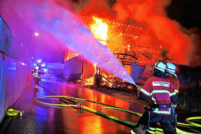 Die Feuerwehr sorgt dafür, dass die Flammen nicht auch auf die angrenzenden Gebäude übergreift.