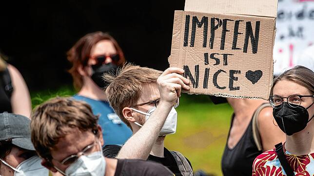 &bdquo;Impfen ist Nice&ldquo; steht auf dem Schild eines Demonstranten, der an einer Gegen-Demonstration teilnimmt, die sich gegen die ...
