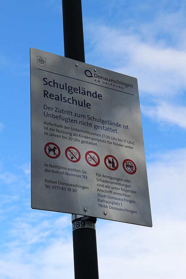 Schilder regeln an der Schule die Nutzung des Pausenhofs. Der kann außerhalb der Unterrichtszeiten von Kindern unter 14 Jahren benutzt ...