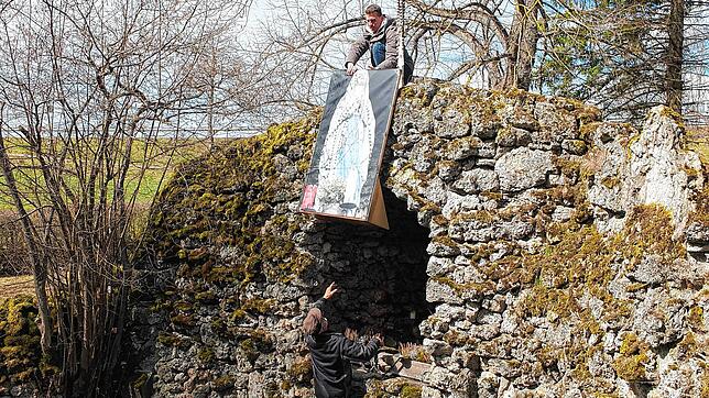 Stefan Fornal und Michael Käfer stellen die Ersatz-Madonna auf Leinwand in der Grotte auf.