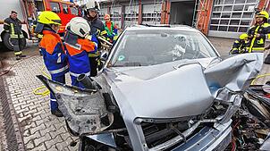 Mit der Rettungsschere müssen die Nachwuchsfeuerwehrleute den Fahrer eines Unfallautos befreien.