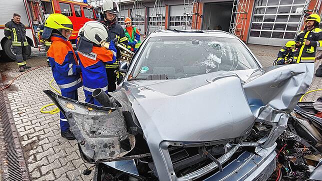 Mit der Rettungsschere müssen die Nachwuchsfeuerwehrleute den Fahrer eines Unfallautos befreien.