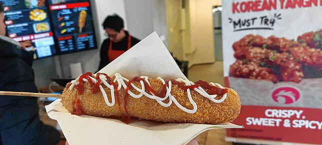Der Corn Dog mit zweierlei Soßen: Mayo und Ketchup. Wer will, kann auch Senf oder eine koreanische Soße nehmen.
