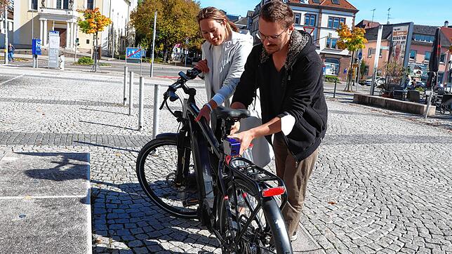 Max Schmid (rechts), Masterstudent der Hochschule Karsruhe, bringt am städtischen E-Bike den Sensor an, der in Verbindung mit einem ...