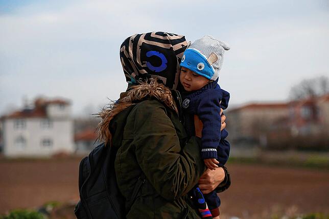 Türkei, Edirne: Eine Migrantin trägt ihr Kind in der Nähe der türkisch-griechischen Grenze. Nachdem die Türkei Anfang März ihre Grenzen ...