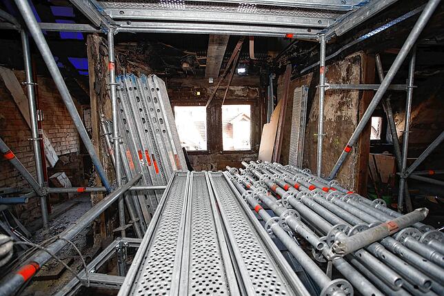 Durch Dachstuhlfenster wurden verkohlte Balken und weiterer Müll durch einen Schutttunnel in den Hinterhof verbracht.
