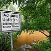 Am Neckarufer bei Nürtingen steht ein Warnschild mit der Aufschrift: &bdquo;Achtung Untiefen! Lebensgefahr! Betreten verboten.&ldquo;