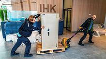 Es geht voran beim Einzug ins neue IHK-Domizil: Mit 800 Kilogramm ist der Safe das schwerste Möbelstück, das Klaus Aberle (rechts) und ...