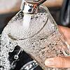 Am Wasserhahn in einer Küche wird ein Trinkglas mit Leitungswasser befüllt. (Symbolbild)