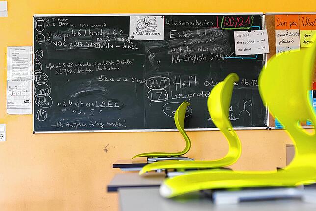 Stühle stehen auf Tischen in einem leeren Klassenzimmer einer Realschule. (Archiv)