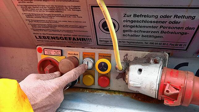 Nur geschultes Personal darf die Presse in Gang setzen. Aufkleber weisen darauf hin, was zu tun ist, wenn jemand in die Presse geraten ist.