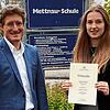 Carla Bickel zeigt stolz ihre Urkunde. Auch Schulleiter Matthias Libruks freut sich.