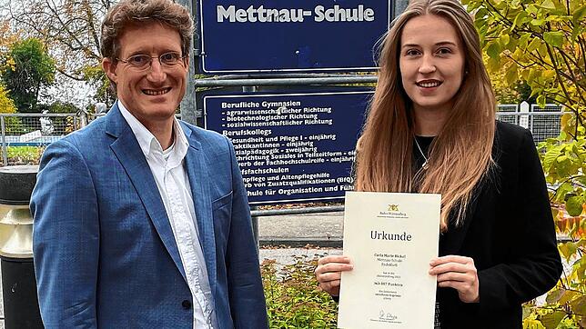 Carla Bickel zeigt stolz ihre Urkunde. Auch Schulleiter Matthias Libruks freut sich.