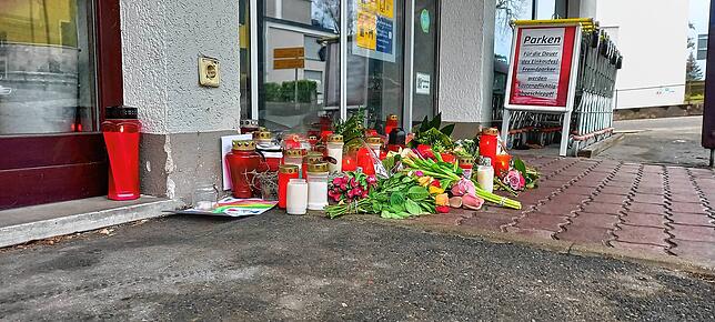 Blumen und Kerzen vor dem Geschäft. Die Anteilnahme der Menschen ist groß.