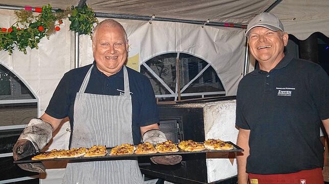 Die ofenheißen Dinnele gingen am Freitagabend weg wie warme Semmeln. Bürgermeister Daniel Heß (links) und sein Bruder, ...