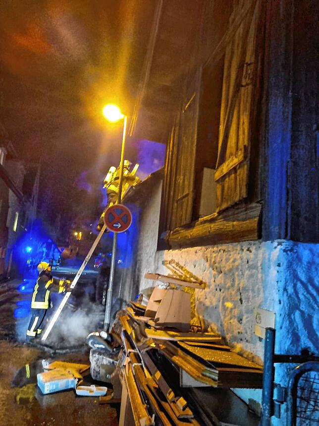 Gibt es noch Glutnester? Die Flammen eines brennenden Sperrmüllhaufens greifen auf einen Schuppen über.