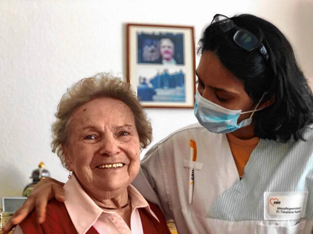 Karina Timalsina, Auszubildende aus Nepal, unterhält sich mit Heimbewohnerin Monika Mühleisen. Derzeit müssen die Mitarbeiter Mundschutz ...
