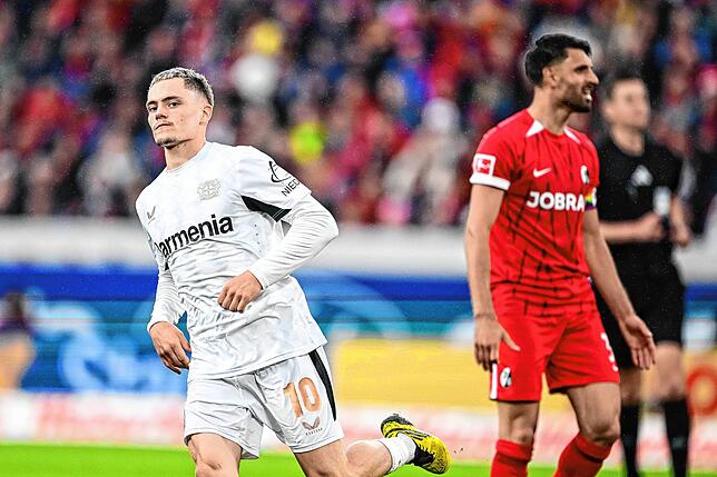 Leverkusens Florian Wirtz (l) nach seinem Treffer zum 2:1 Freiburgs Vincenzo Grifo reagiert im Spiel.
