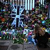 Eine Frau legt Blumen nieder und hinterlässt einen Grußbotschaft vor den Toren des Buckingham Palace.