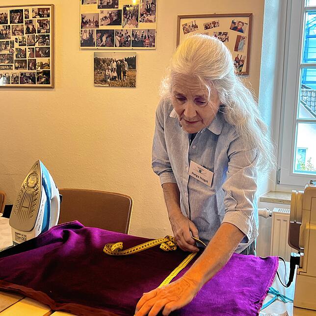 Helga Hügel kennt sich mit Nähen aus und kürzt einen Kissenbezug für eine Dame.
