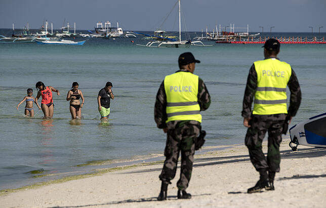 Ein Polizist auf der philipinischen Insel Boracay patrouliert entlang des Strandes. Die Insel ist seit April diesen Jahres für sechs ...