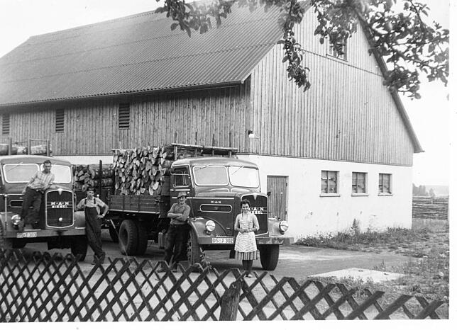 Holztransporte Ende der fünfziger Jahre. Rechts Albin Vogt mit seiner Frau Liselore, links zwei angestellte Fahrer. Im Hintergrund der ...
