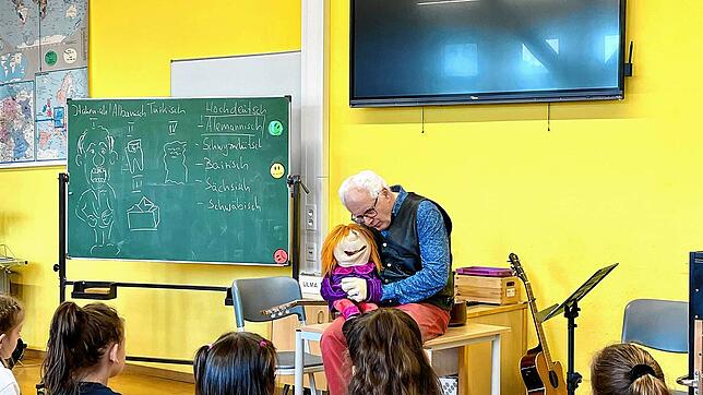 Die etwas andere Schulstunde mit Uli Führe: Er lässt den alemannischen Dialekt gesanglich und mit Handpuppe in der Talschule Wehr ...