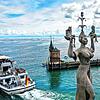 Die Figur &bdquo;Imperia&ldquo; dreht sich an der Hafeneinfahrt von Konstanz, während das Motorschiff Stuttgart aus dem Hafen hinausfährt.