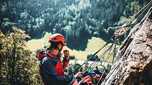 Hoch oben am Fels: Ein Mitglied der Bergwacht in Aktion. Foto: Bergwacht