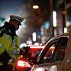 Ein Polizist kontrolliert im Dezember in Stuttgart, ob der Fahrer einen triftigen Grund für seine nächtliche Fahrt hat. Bilder: dpa
