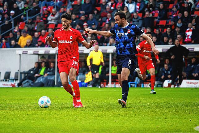 Eren Sami Dinkci (l) und Heidenheims Benedikt Gimber (r) im Laufduell.