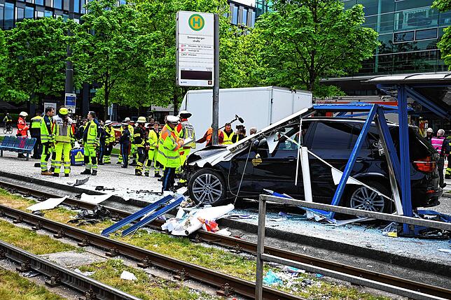 Einsatzkräfte der Polizei und Feuerwehr stehen an der Unfallstelle.