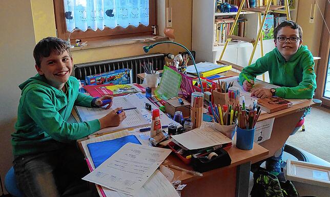 Der neunjährige Julian und sein elfjähriger Bruder Marius Pittermann an ihrem Schreibtisch.