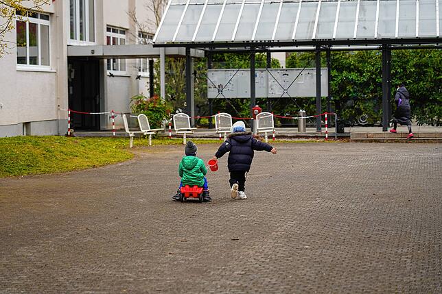 Kinder spielen ausgelassen im Hof – die Gesichter der Eltern aber zeigen die Spuren der Strapazen. Zu ihrem Schutz werden sie hier ...