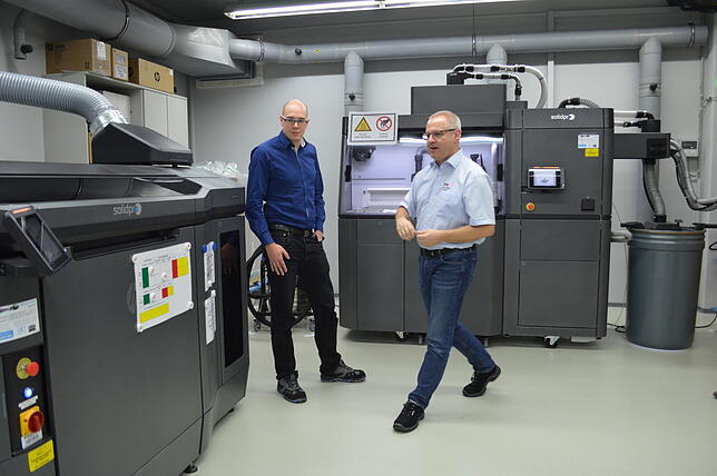Michael Kniepkamp (links), zuständig für die 3D-Druck-Produktion, und Andreas Blank, Ausbilder, erklären, wie ein 3D-Drucker funktioniert.
