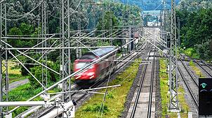 Eine Diesellok fährt 2021 auf der Südbahnstrecke von Ulm nach Friedrichshafen unter den neu installierten Oberleitungen durch. Ende 2027 ...