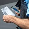 Ein Bundespolizist kontrolliert am Grenzübergang die Papiere eines Reisenden.