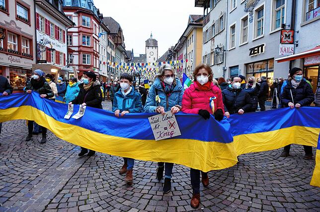 Blau-gelbe Verbindung: Ein langes Band, gehalten von vielen Menschen, symbolisiert die Solidarität mit der Ukraine.