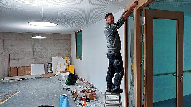 Schreiner Markus Jönen und weitere Handwerker erledigen letzte Arbeiten, damit das Haus Ende September nach und nach bezogen werden kann.