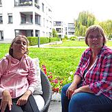 Sabine und Nicola Weiß sitzen auf der Terrasse mit Blick in den Innenhof des Wobak-Komplexes.