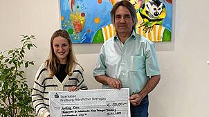 Lilly Schneider übergibt Claus Geppert vom Freiburger Förderverein für krebskranke Kinder 50¦Euro.