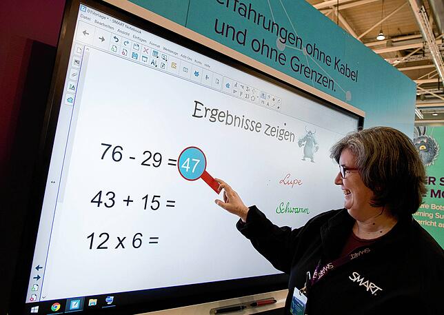 Eine Lehrerin steht vor einen digitalen Schultafel auf der Bildungsmesse Didacta in der Messe Hannover.