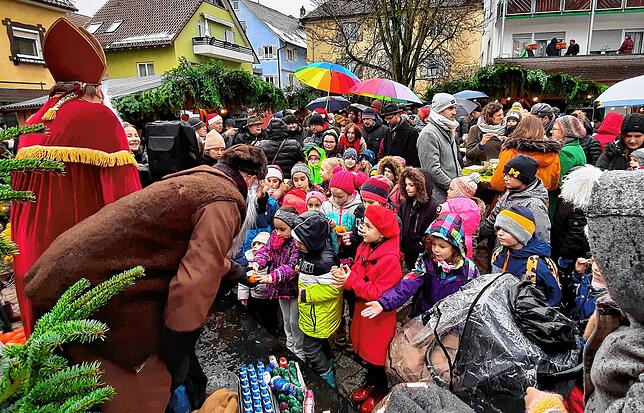 Knecht Ruprecht verteilt mehr als 150 gespendete Schokonikoläuse mit Clementinen.