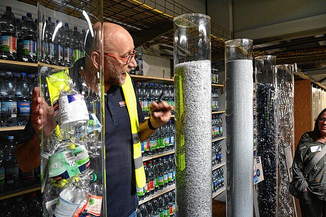 Marketingleiter Michael Neuenhagen zeigt die Schritte von der gequetschten PET-Flasche zur neuen Flasche.