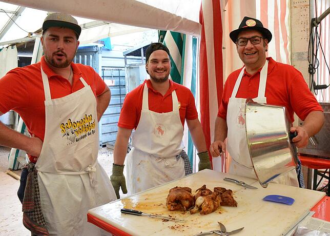 Bei Simon Hettich (von links), Adrain Schwer und Claudius Hipp gibt es die Volksfestspezialität, die gegrillten Hähnchen, direkt vom ...