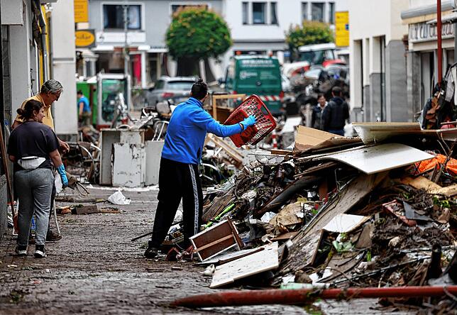 Menschen räumen in der Fußgängerzone von Gemünd in Nordrhein-Westfalenauf , nachdem die Urft über die Ufer getreten war.
