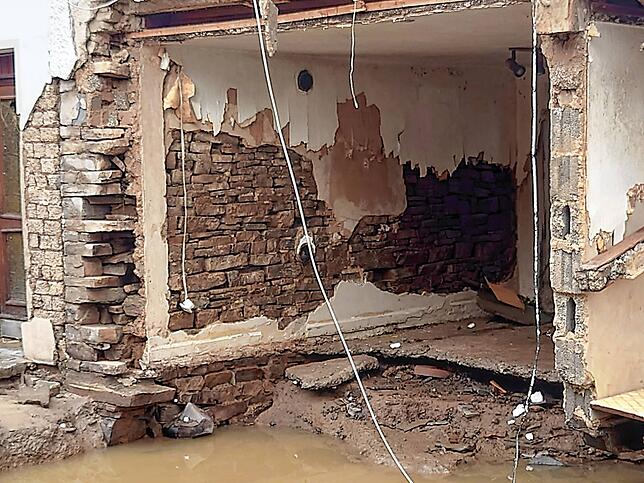 So sah das ehemalige Wohnzimmer direkt nach dem Hochwasser aus, mit bloßer Backsteinwand und der halbe Boden fehlt. Alles ist unterspült.