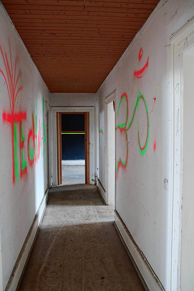 Neongrün und neonpink vollgeschmierte Wände im Rheinschloss. Links steht „Techno“, links das hinduistische Om-Zeichen.