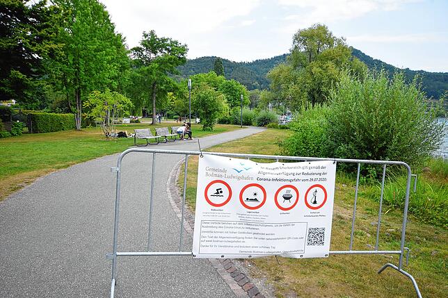 Banner auf Zäunen wie dieses am Eingang des Schlössleparks in Ludwigshafen weisen auf das geltende Lager- und Badeverbot hin.
